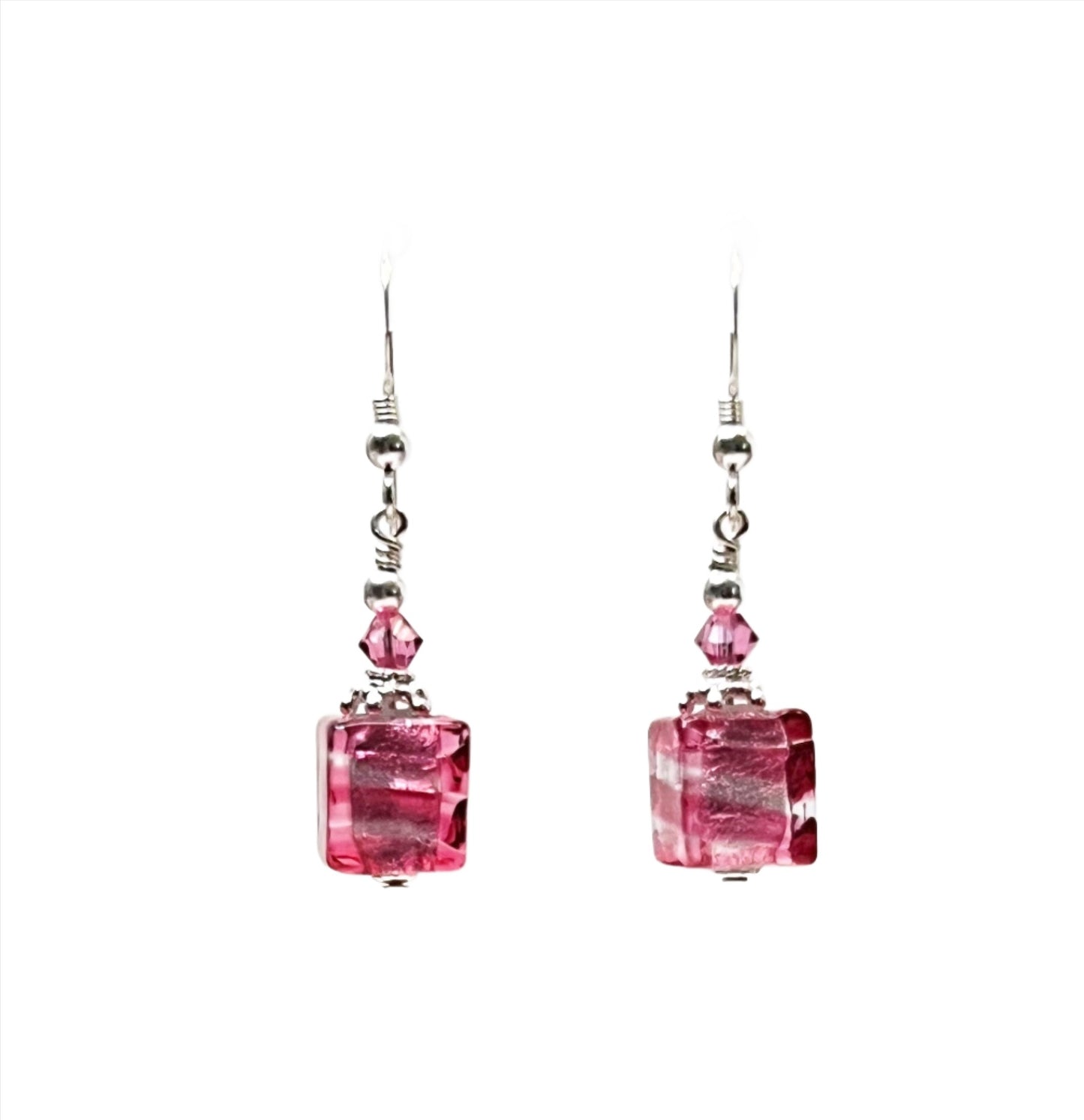 a pair of earrings with pink stones hanging from them