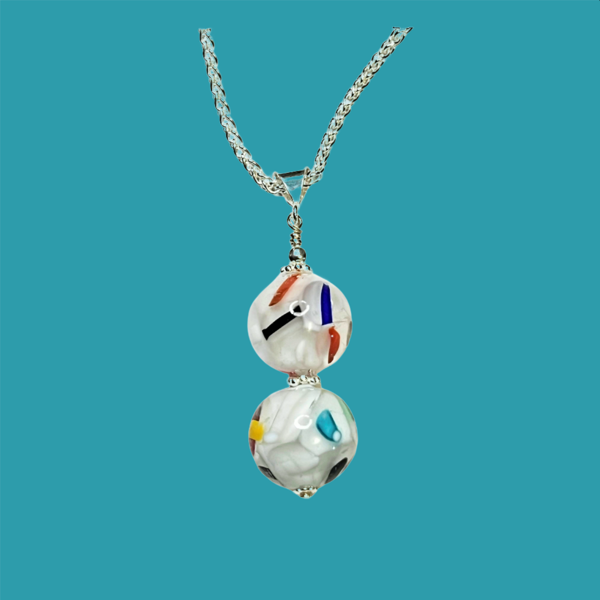 a couple of necklaces sitting on top of a white surface