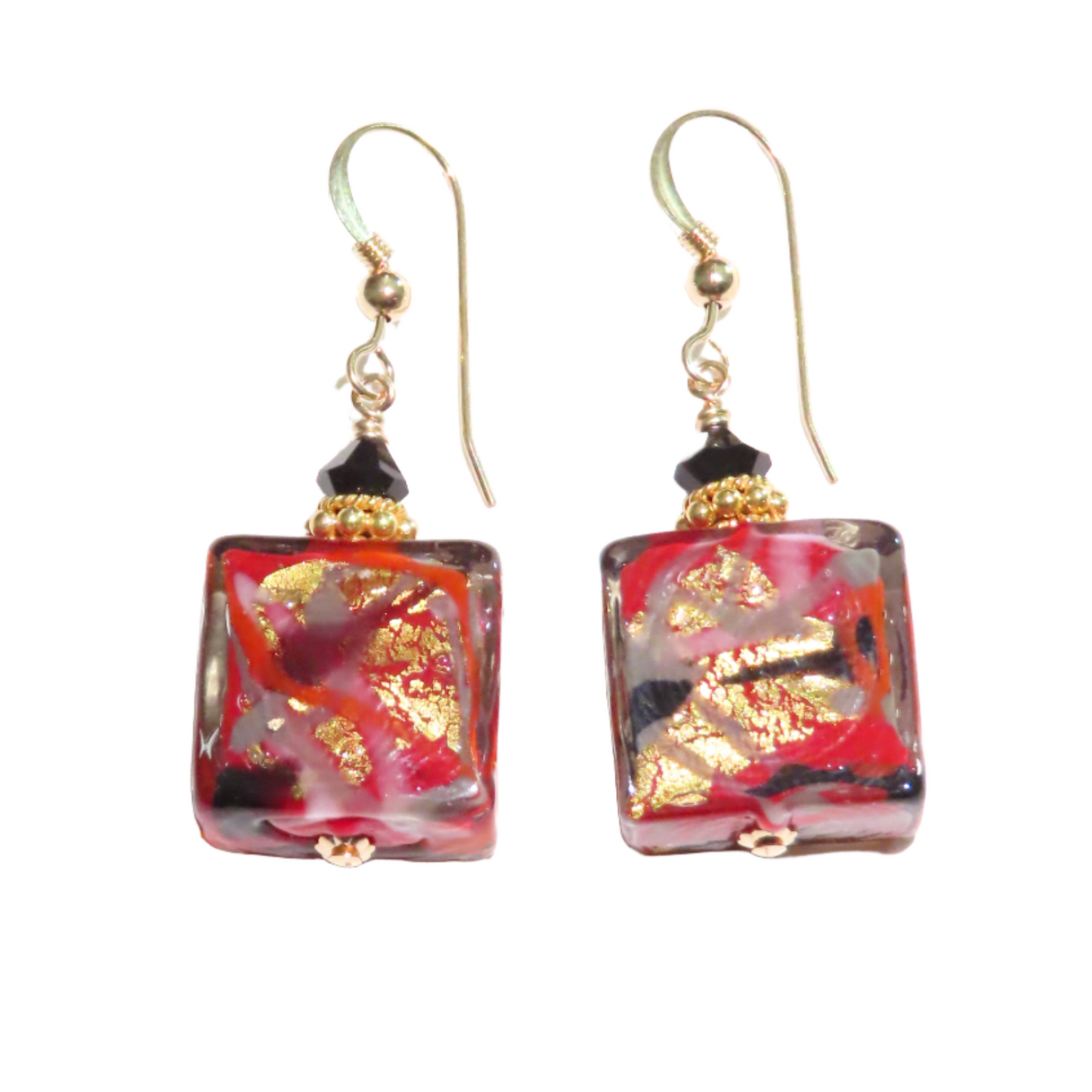 a pair of red and gold earrings on a white background
