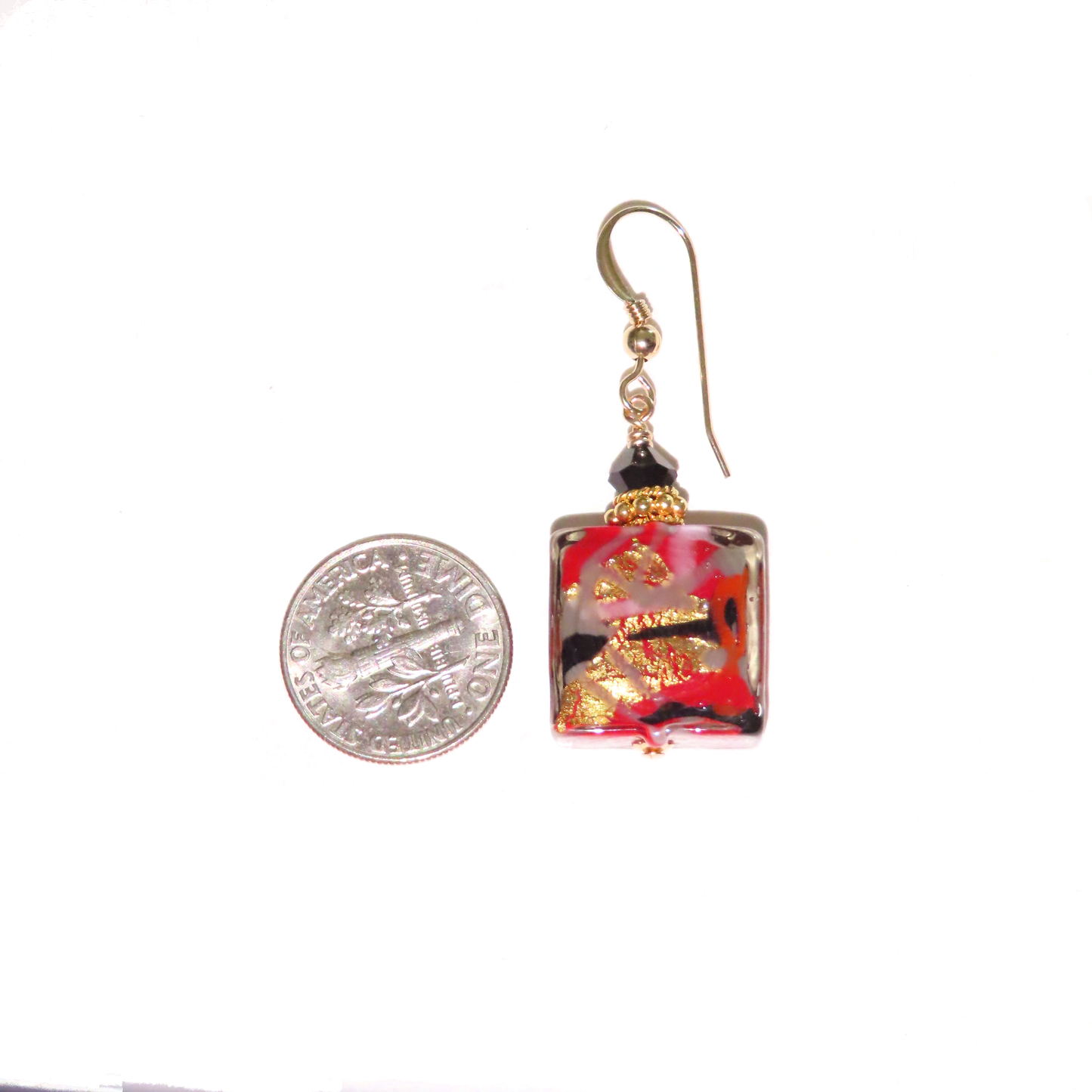 a pair of earrings sitting next to a coin