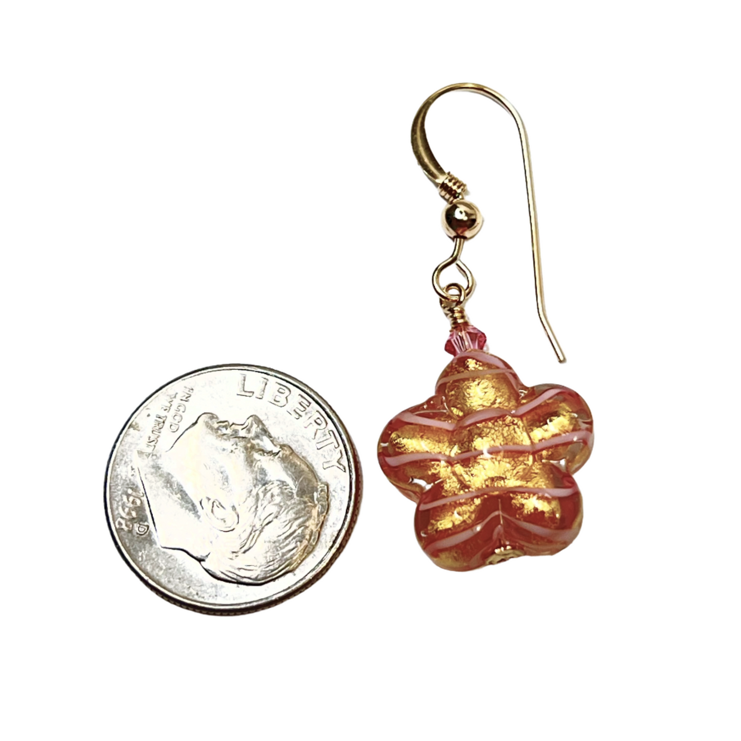 a pair of red and gold earrings next to a penny