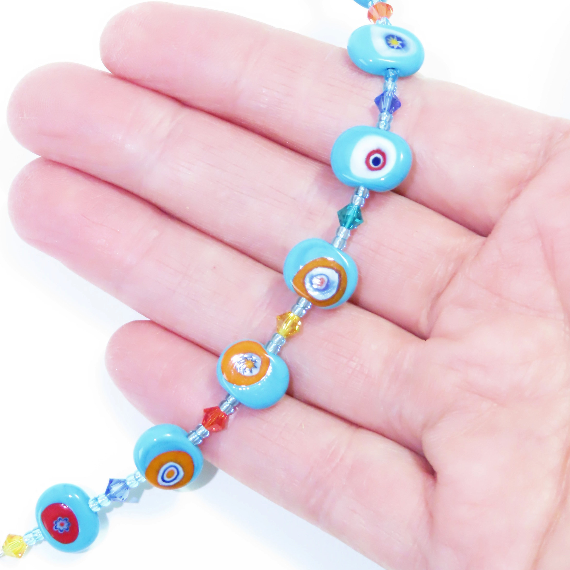 a hand holding a blue beaded bracelet